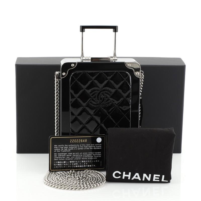 This Chanel Trolley Minaudiere Plexiglass and Quilted Patent, crafted from black plexiglass and black quilted leather, features chain-link crossbody strap, rolling suitcase silhouette, Chanel CC logo stitched in the center and silver-tone hardware.