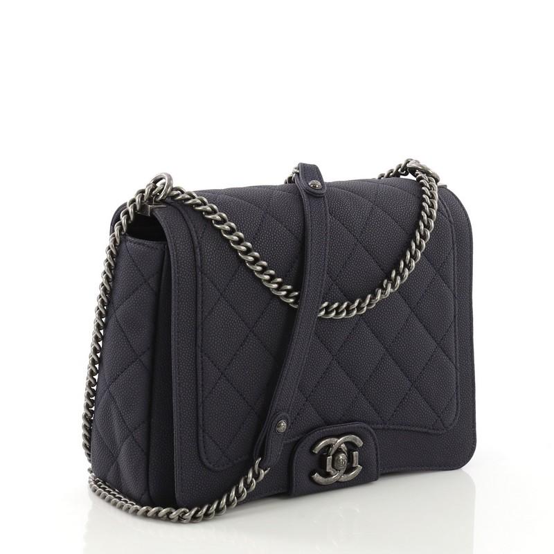 This Chanel Turn Around Ligne Flap Bag Quilted Washed Caviar Medium, crafted in blue quilted washed caviar leather, features aged silver chain-link strap with leather pad, CC push-lock closure, and aged silver-tone hardware. Its push-lock closure