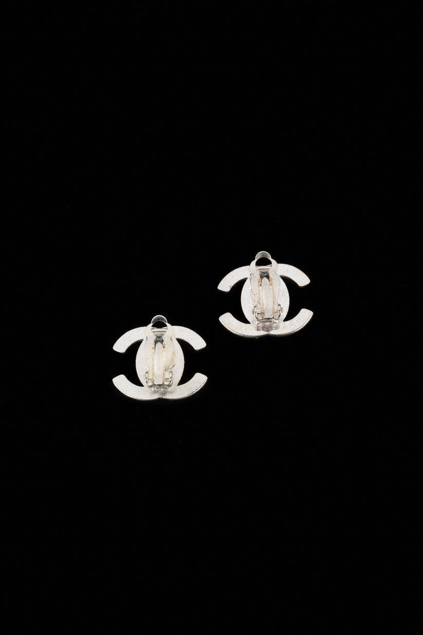 Chanel- (Made in France) Silvery metal turnlock earrings ornamented with Swarovski rhinestones. 1996 Fall-winter Collection.

Additional information:
Condition: Very good condition
Dimensions: 1.6 cm x 2.2 cm
Period: 20th Century

Seller Reference: