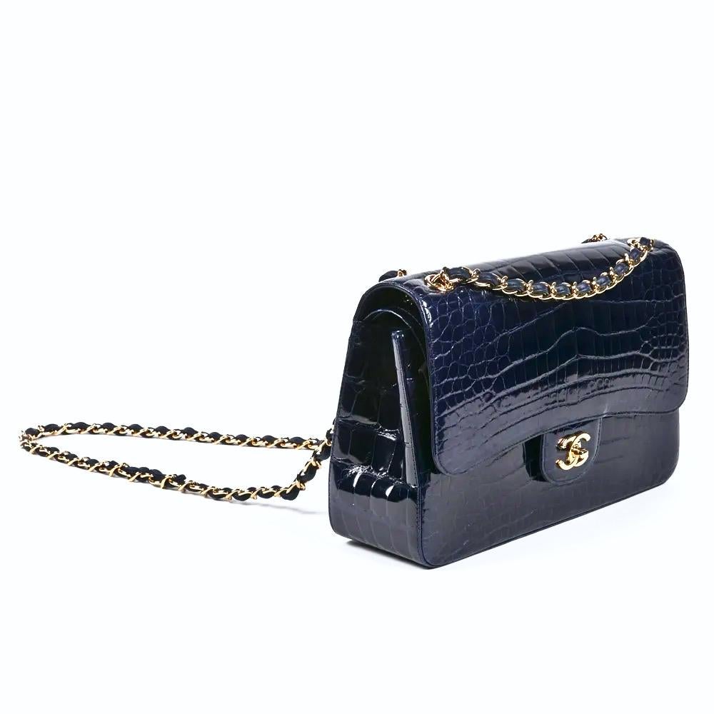 Rare Navy CHANEL Alligator Jumbo Double Flap Bag is a must for any collector of exotic handbags in general and Chanel bags in particular! Features navy shiny alligator leather with gold-tone hardware, CC turn-lock closure, convertible leather chain