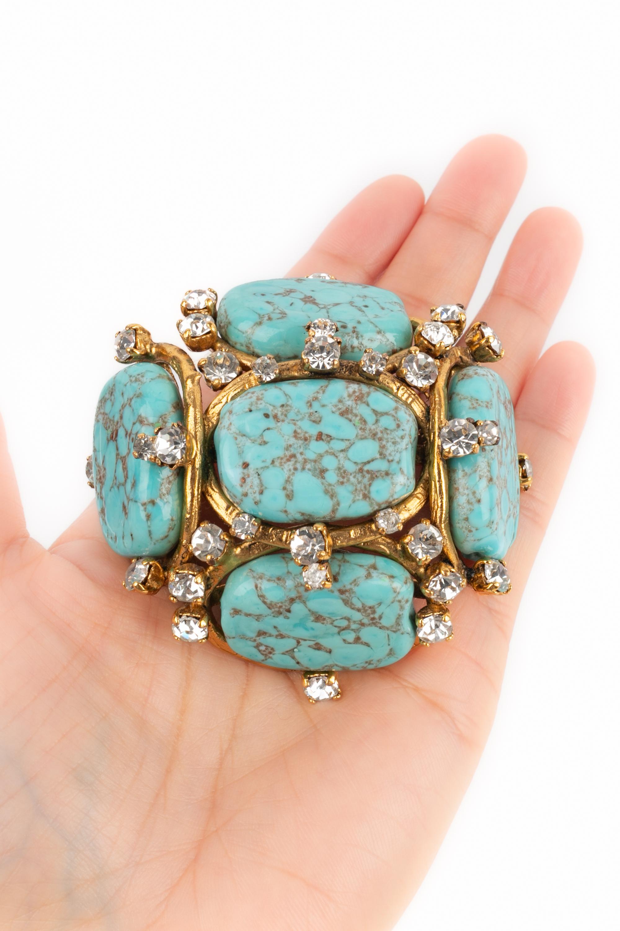 CHANEL - (Made in France) Golden metal brooch with turquoise-like glass paste pearls. 1994 Spring-Summer Collection under the artistic direction of Karl Lagerfeld.

Condition:
Very good condition

Dimensions:
7 cm x 7 cm

SKU:BRB115