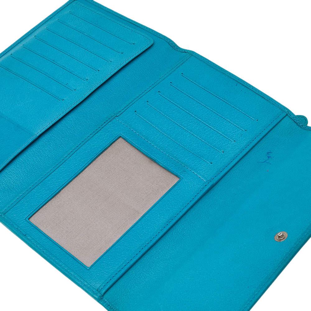 Infusing a signature touch to the classic style, this continental flap wallet from Chanel provides a functional structure brimming with durability. It is crafted with turquoise leather and features a silver-toned logo attached to the embossed