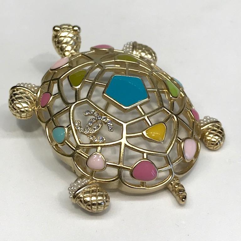 Chanel satin gold tone and pastel enamel openwork turtle brooch with rhinestone interlocking CC logo from the 2019 Cruise collection. Pastel turquoise, yellow, pink, light blue and dusty rose enamel. Openwork domed shell and tiny faux seed pearl