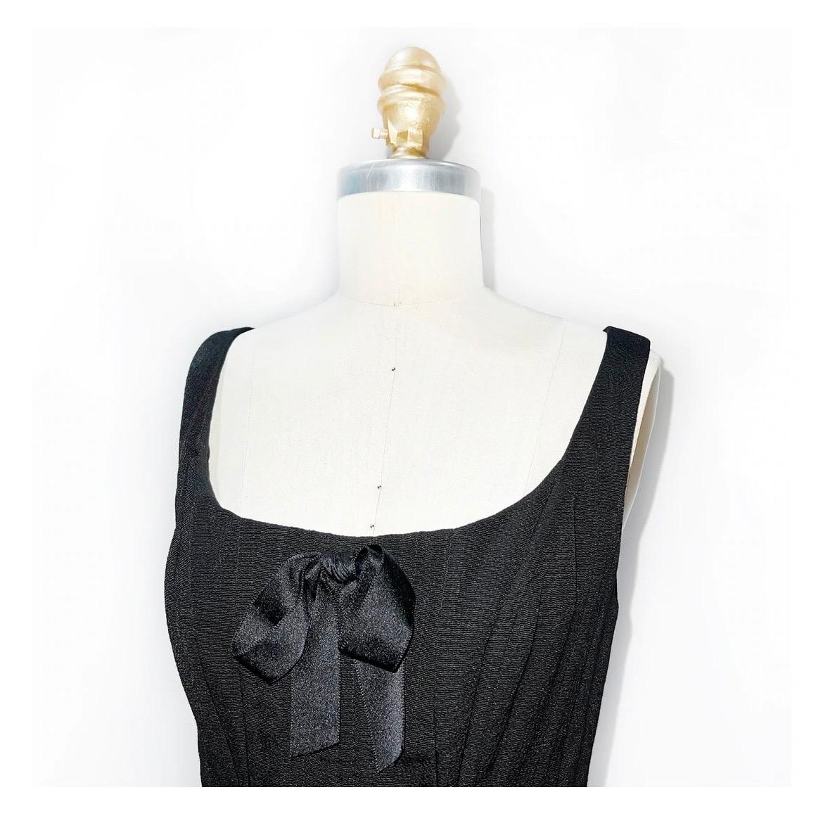 Chanel by Karl Lagerfeld Bustier 
Spring / Summer 1993 
Look 100 
Made in France
Vintage 
Black 
Tank style straps with open neckline 
Corset boning inside bustier for support 
Black satin bow at bustline 
Black satin detailing at pockets and at
