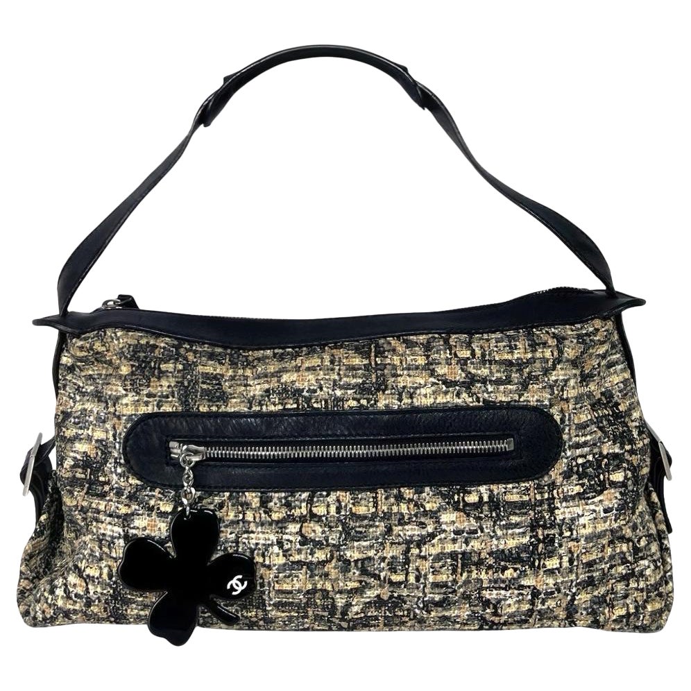 Magnifique sac à main CHANEL réalisé en tweed beige et noir rehaussé de finitions en cuir noir et d'une bijouterie argentée. Créé sous la direction de Karl Lagerfeld au milieu des années 2000, ce modèle illustre l'art de la Maison à fusionner les