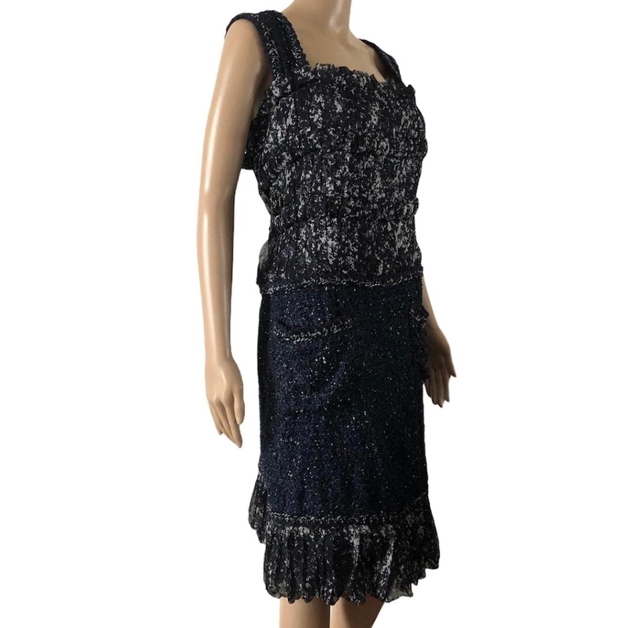 Chanel Tweed and silk Dress Navy Color,  size french 36 but fits size 34. Beautiful Chanel dress in blue tweed and chiffon. Spring-summer collection 2012.
Bottom of the skirt with ruffles.
2 pockets, one with a CC logo button.
Discreet CC logo zip