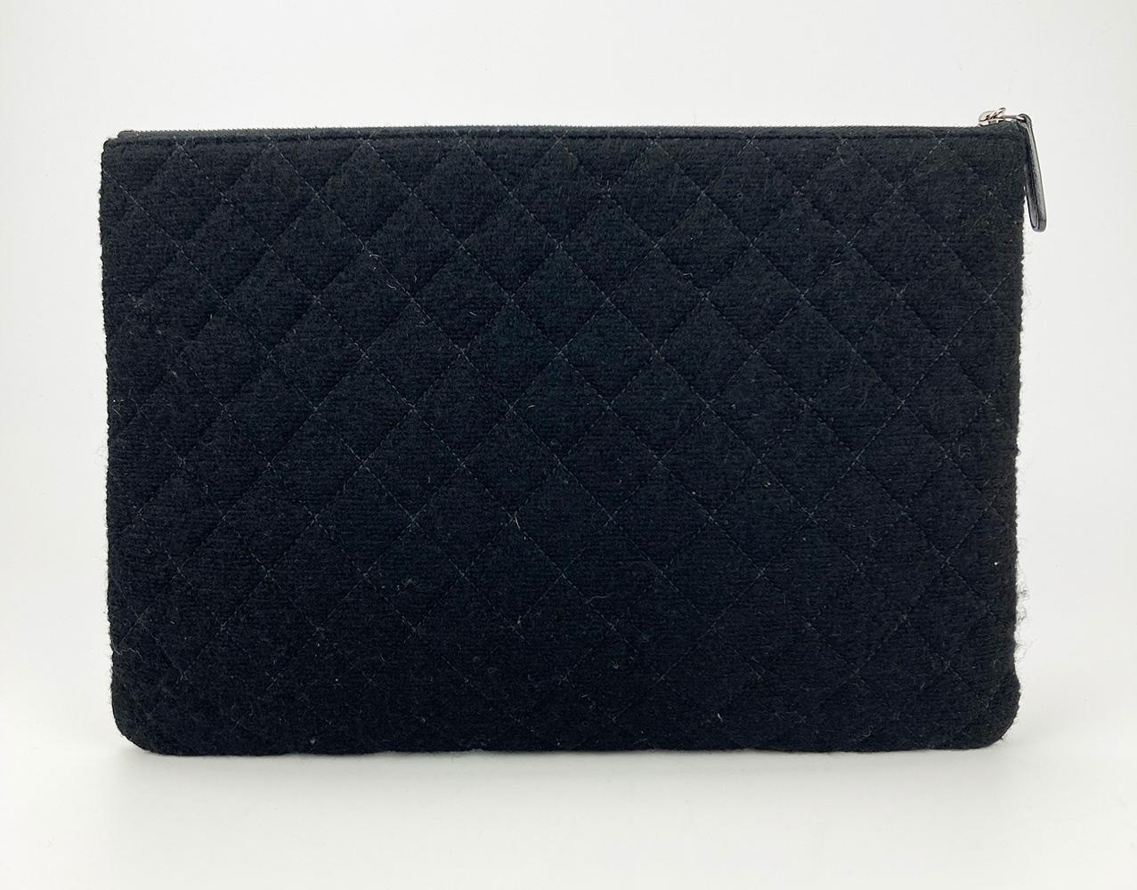 Chanel Tweed and Wool Zipped Pouch in NWOT condition. Multi color quilted tweed and wool exterior trimmed with a delicate gunmetal floral charm and CC logo along front side. Top zip closure opens to a black quilted soft nylon interior. Like new