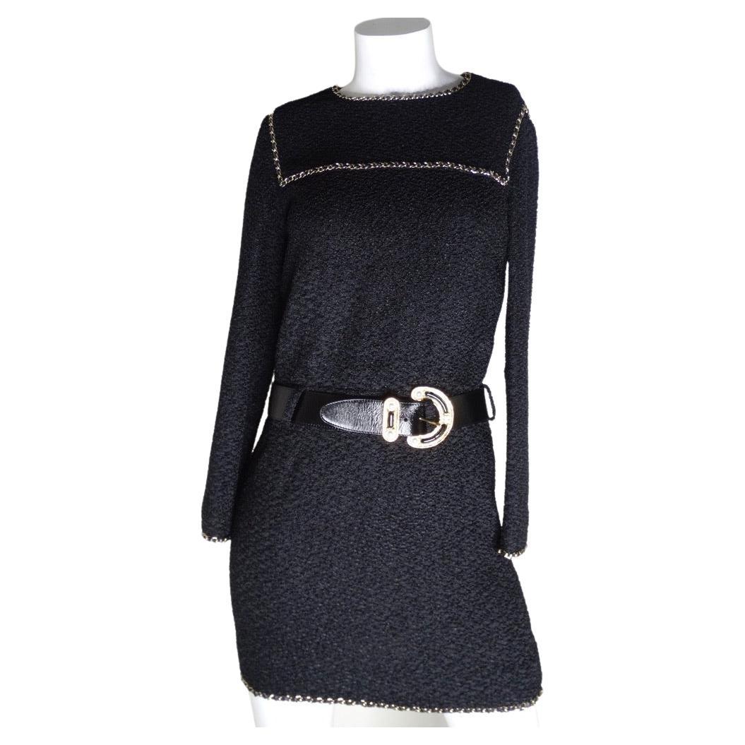 Dieses zeitlose Tweedkleid mit Gürtel von Chanel muss unbedingt in Ihre Sammlung aufgenommen werden! Mit der klassischen Chanel-Lederkette und einem schwarzen Ledergürtel mit einer großzügigen gravierten Schnalle. Die Rückseite des Kleides ist ein