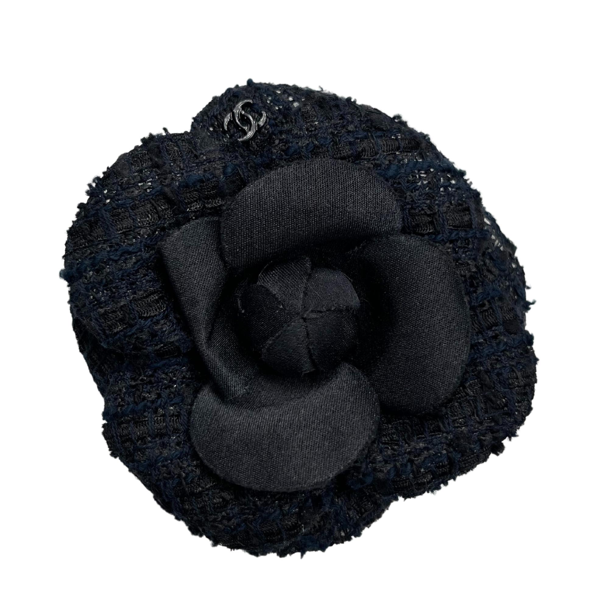Camélia Chanel brooch in black tweed with the Chanel logo visible on a petal.

Color: Black
Material: Tweed
Clasp Style:
Condition: Excellent.
Comes With: Chanel vendor bag
Measures: 3” x 3”