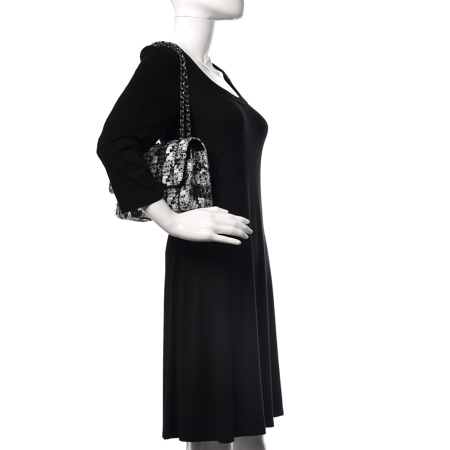 Esta Solapa Chanel es de 2005-2006 y la diseñó Karl Lagerfeld. El bolso está confeccionado en tweed azul oscuro y negro, tiene herrajes de rutenio, una correa para el hombro de eslabones de cadena entretejidos con piel y una solapa delantera con