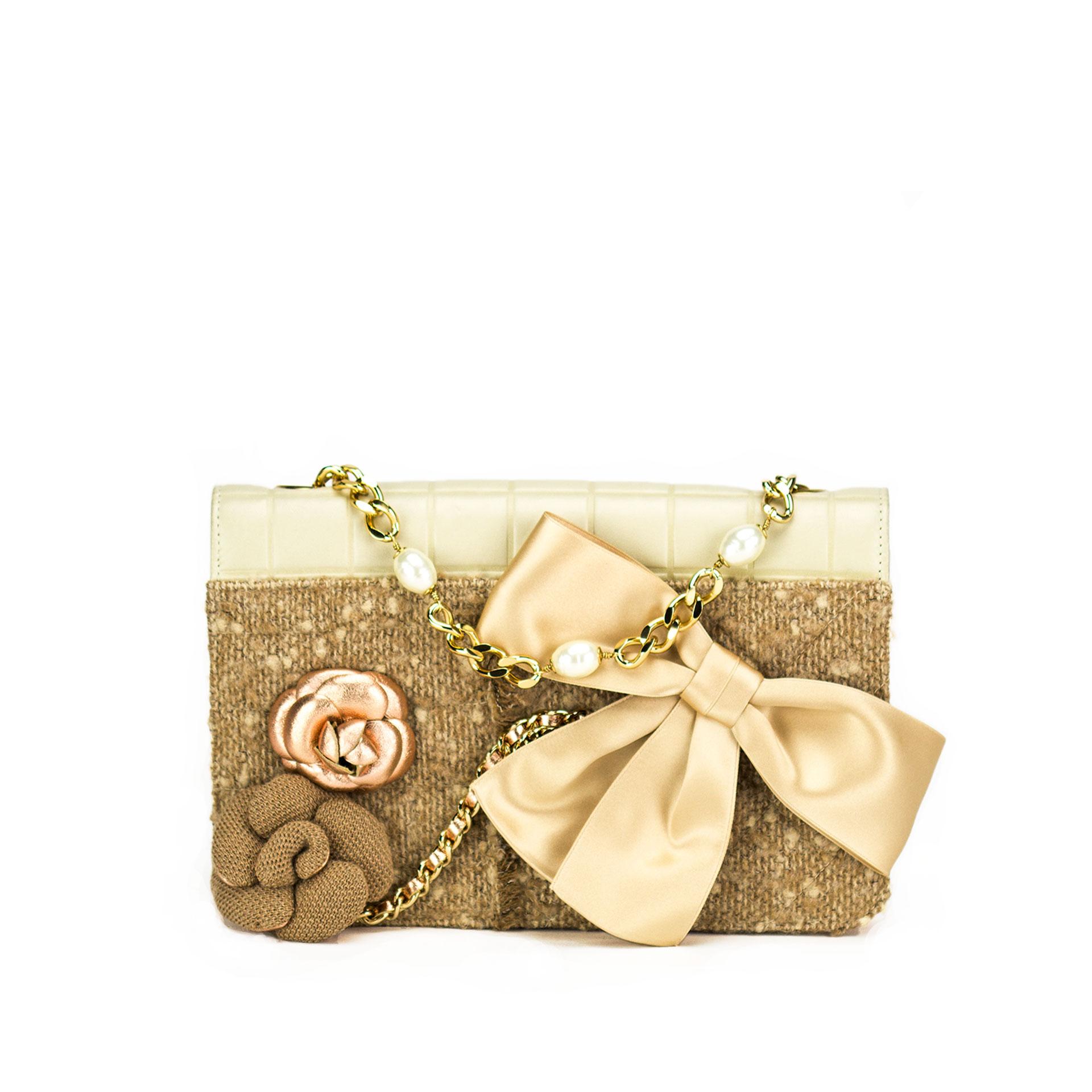 Beige Chanel quilted lambskin and tweed flap with attached camelia flower and bow

2001 {VINTAGE 19 Years}
Gold hardware
Hanging pearl detail
Lion head button detail
Pearl chain
Interior rose gold lining
Interior pocket
Classic back pocket
Strap