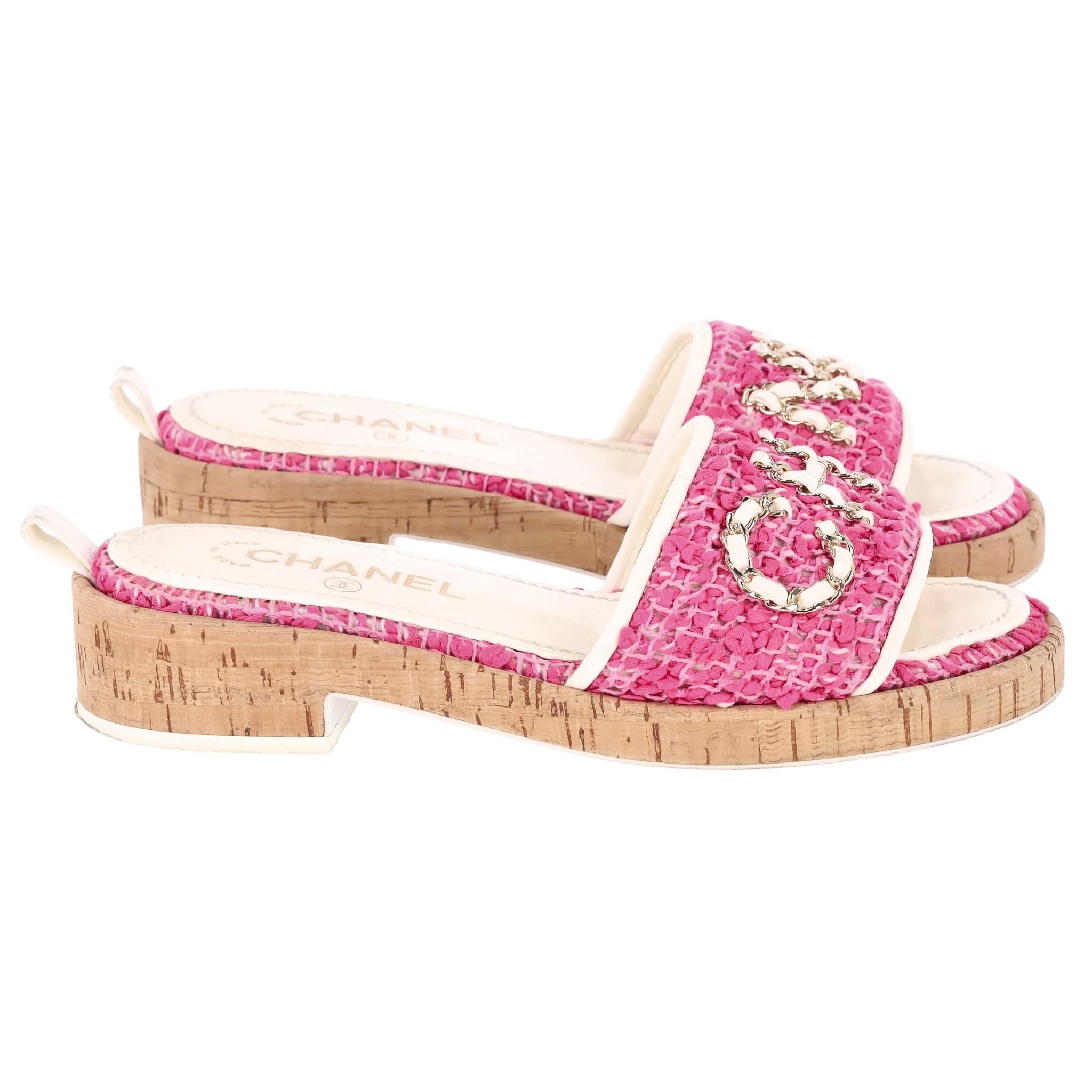 Chanel Tweed 'Chanel' Logo Sandals

Pink tweed mules designed with iconic white leather and gold chain 'CHANEL' lettering to the front.

Featuring white leather trimmed straps and contrasting tweed trimmed leather insoles.

Detailed with light brown