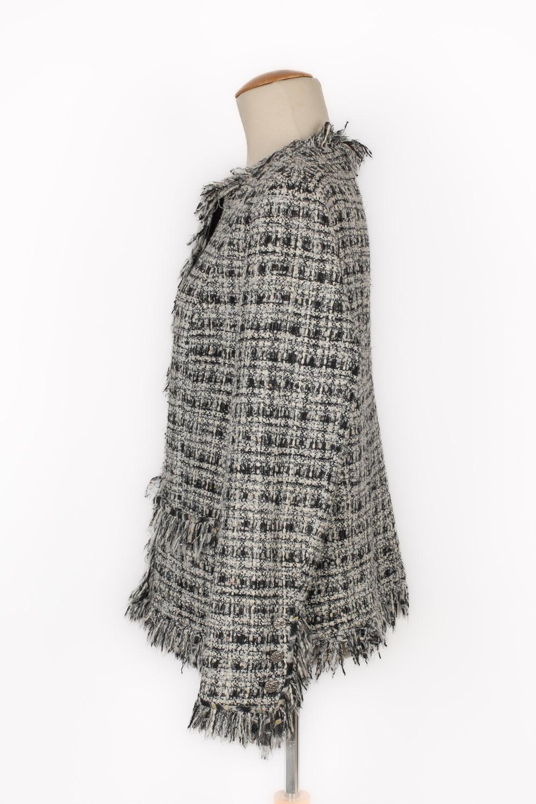 Chanel - (Made in France) Tweed jacket edged with fringes, and with silvery metal buttons. Size 42FR indicated. 2004 Spring-Summer Collection under the direction of Karl Lagerfeld.

Additional information:
Condition: Very good condition
Dimensions: