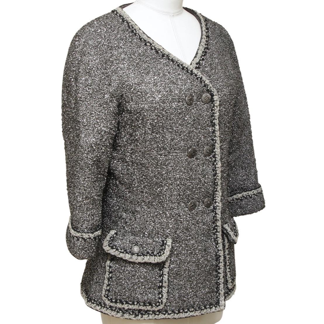 GUARANTEED AUTHENTIC CHANEL 2014 SPRING COLLECTION METALLIC FANTASY TWEED DOUBLE BREAST JACKET

Retailed excluding sales taxes $4,920.

Details:
• Double breast jacket in a silver metallic fantasy tweed.
• Collarless.
• V-neck.
• Front flap