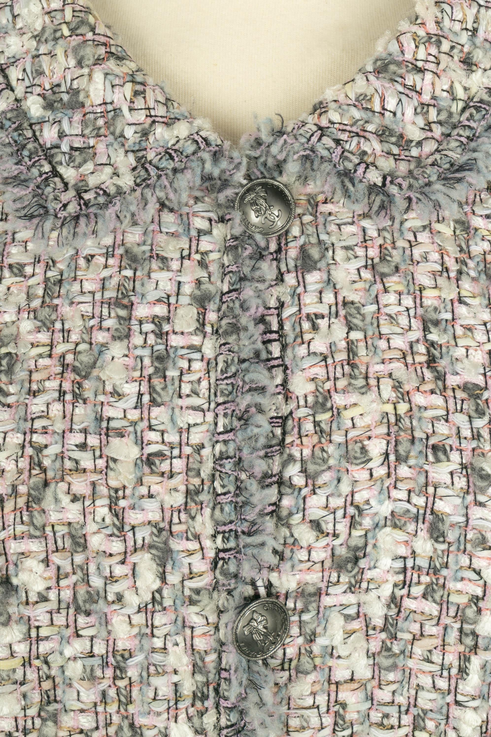 Chanel - (Made in France) Giacca in tweed nei toni del rosa e del blu grigiastro. Bottoni in metallo argentato. Non è indicata la taglia, ma si adatta a una 36FR/38FR.

Condizioni:
Ottime condizioni

Dimensioni:
Larghezza spalle: 40 cm - Petto: 54