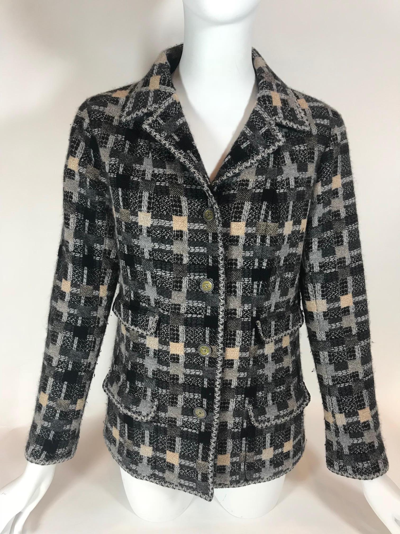 From the Spring 2014 Collection. Black and multicolor Chanel tweed jacket featuring checkered knit pattern. Collared. Long sleeve. Button up closures at front. Dual patch pockets at sides, Silver-tone chain at interior hem. Dual buttons on sleeves.