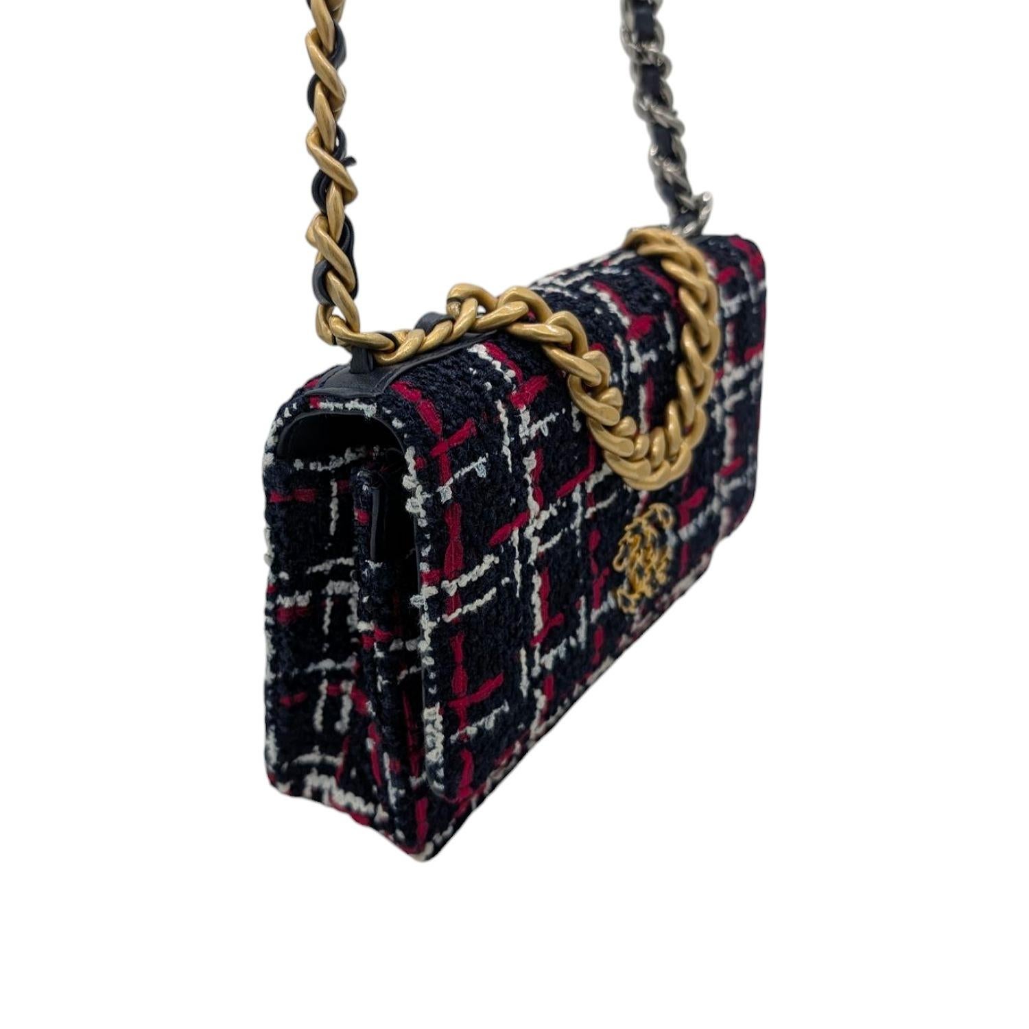 This chic Chanel 19 Wallet On Chain is crafted of woven tweed in red, white and navy blue. The crossbody bag features an aged gold, aged ruthenium and dark silver chain link leather threaded shoulder strap and an aged gold threaded CC logo on the