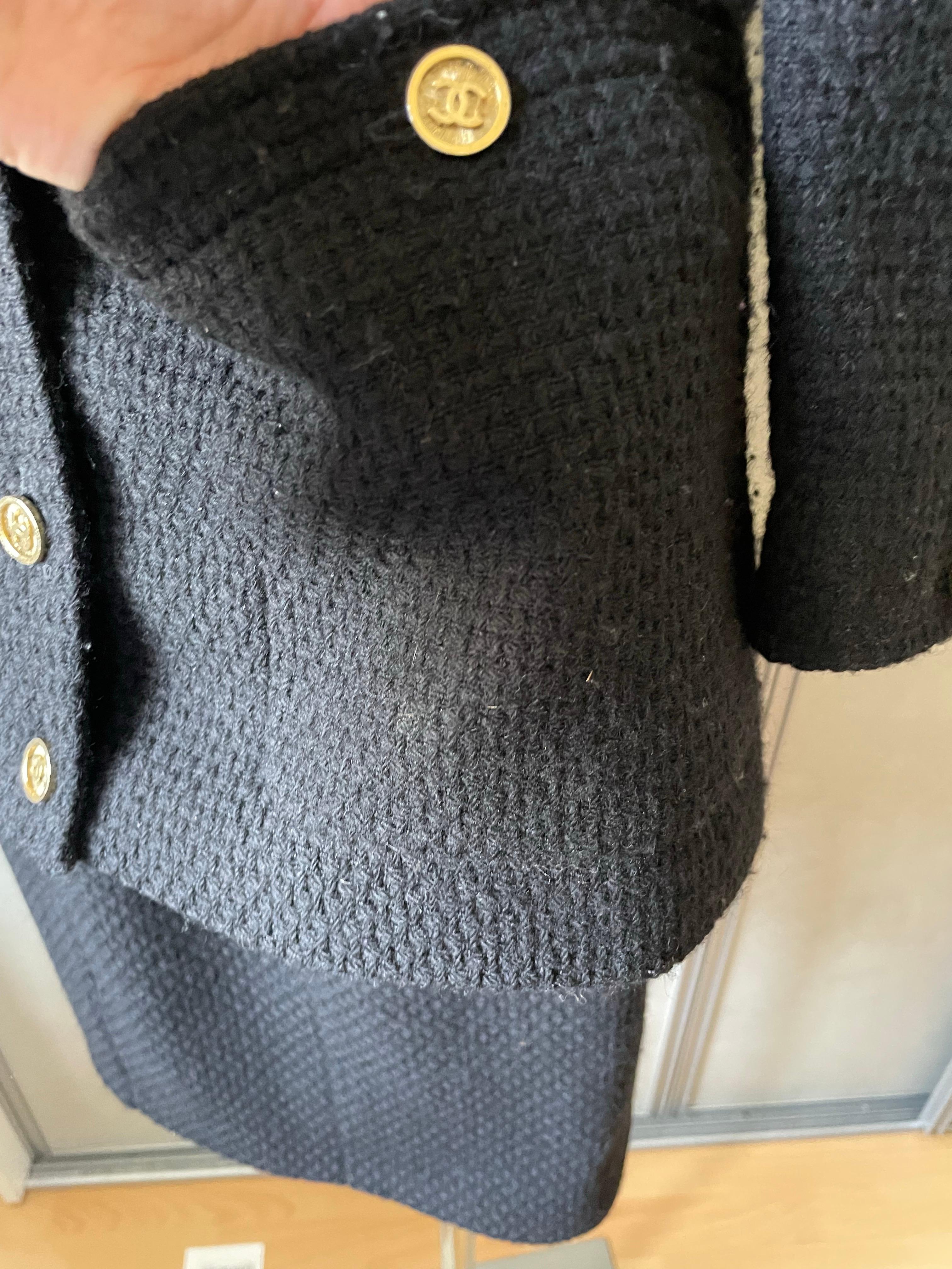 CHANEL. Abito in tweed. Modella la piccola giacca nera. Giacca di media lunghezza con bottoni firmati CC del marchio. Vintage anni '90 di Karl Lagerfeld. Il set è in buone condizioni, con alcune pieghe. La gonna è stata leggermente modificata in