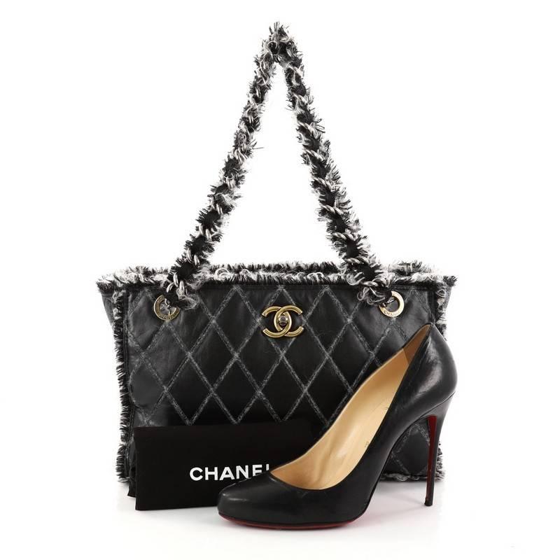 This authentic Chanel Tweedy Tote Quilted Leather Medium is an iconic tote in a versatile sleek style that will compliment a multitude of looks. Crafted from black leather with diamond quilt stitching, this tote features aged gold and silver-tone