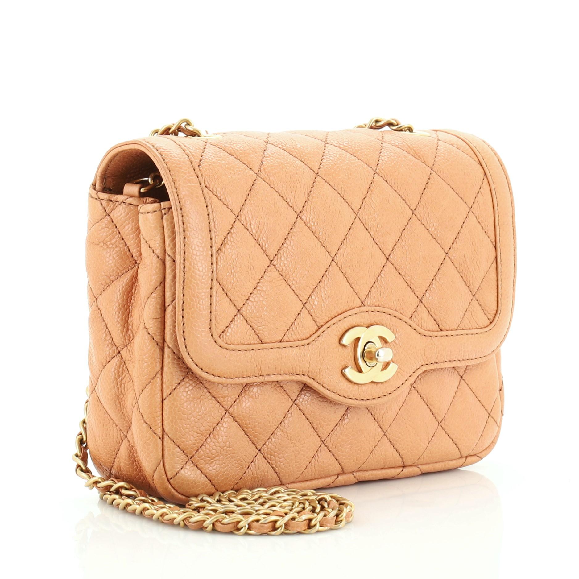 This Chanel Two Tone Flap Bag Quilted Caviar Mini, crafted from brown quilted caviar leather, features woven-in leather chain straps, exterior back slip pocket, and gold-tone hardware. Its CC turn-lock closure opens to a brown leather interior with