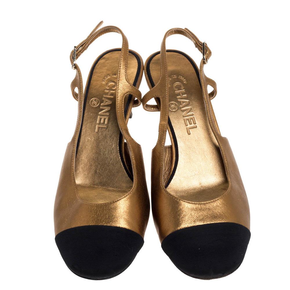 Fetch an elegant look with these Chanel slingback sandals. Crafted from metallic gold & black leather & fabric, they feature contrasting black cap toes. The sandals rest on low 6 cm heels with the CC logo and are finished with comfortable