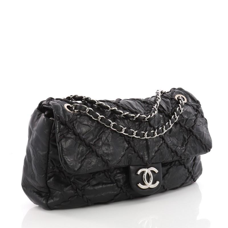 This Chanel Ultra Stitch Flap Bag Quilted Calfskin Jumbo, crafted from black quilted calfskin leather, features oversized diamond leather stitching details, dual woven-in leather chain link strap, and silver-tone hardware. Its hidden magnetic snap
