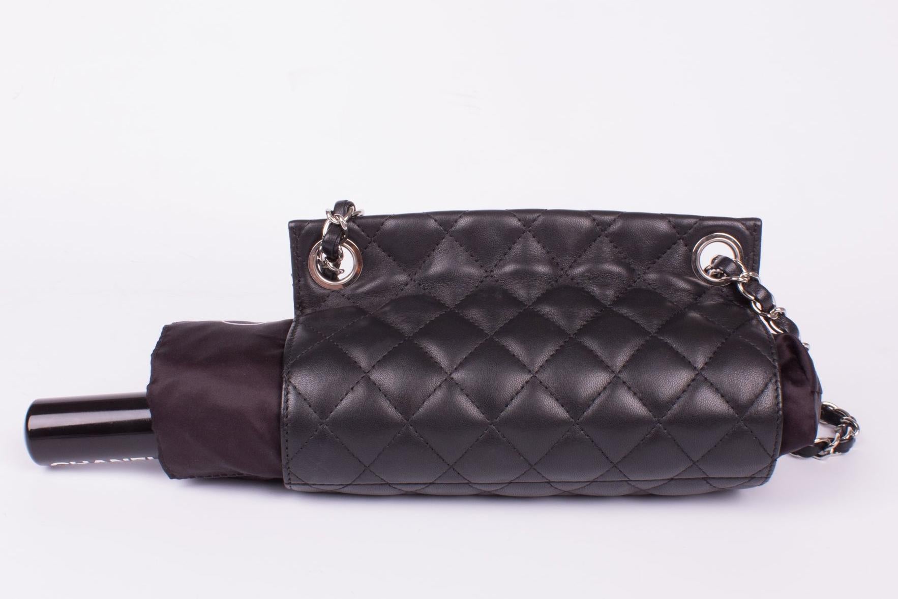 Carry your umbrella in style! This is outrageous... we present the Chanel Umbrella Case Single Flap Bag with a Camellia umbrella.

This black lambskin leather quilted bag has the appearance of a single flap bag and has silvertone hardware. An