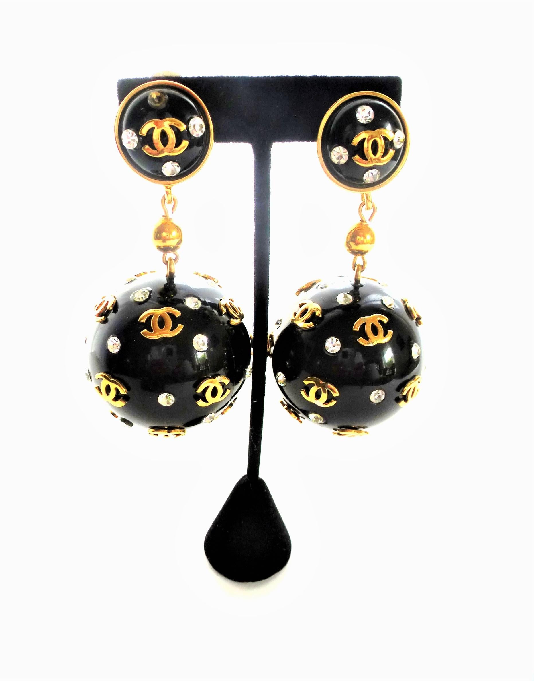 Such great Chanel ball clip on earring set with iconic CC and embedded clear rhinestones. 
Signed CHANEL in capital letters.
Measurement: Full length 9 cm.  Upper part with clip and signature 2 cm in diameter, the large ball has a diameter of 4 cm, 