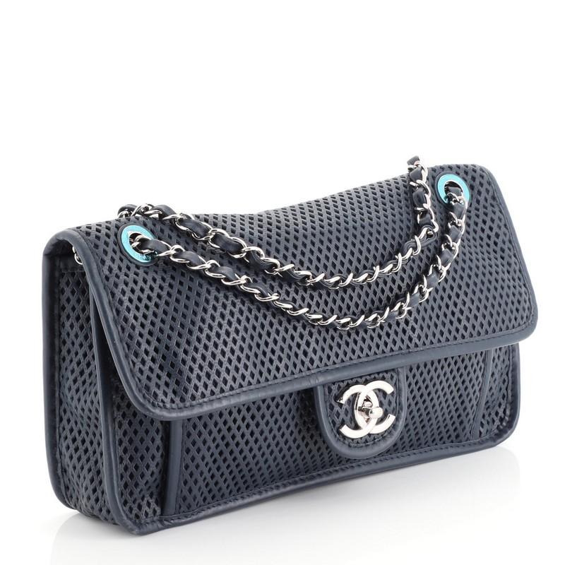 This Chanel Up In The Air Flap Bag Perforated Leather Medium, crafted from blue perforated leather, features woven-in leather chain strap, slip pocket under flap, and silver-tone hardware. Its turn-lock closure opens to a blue fabric interior with