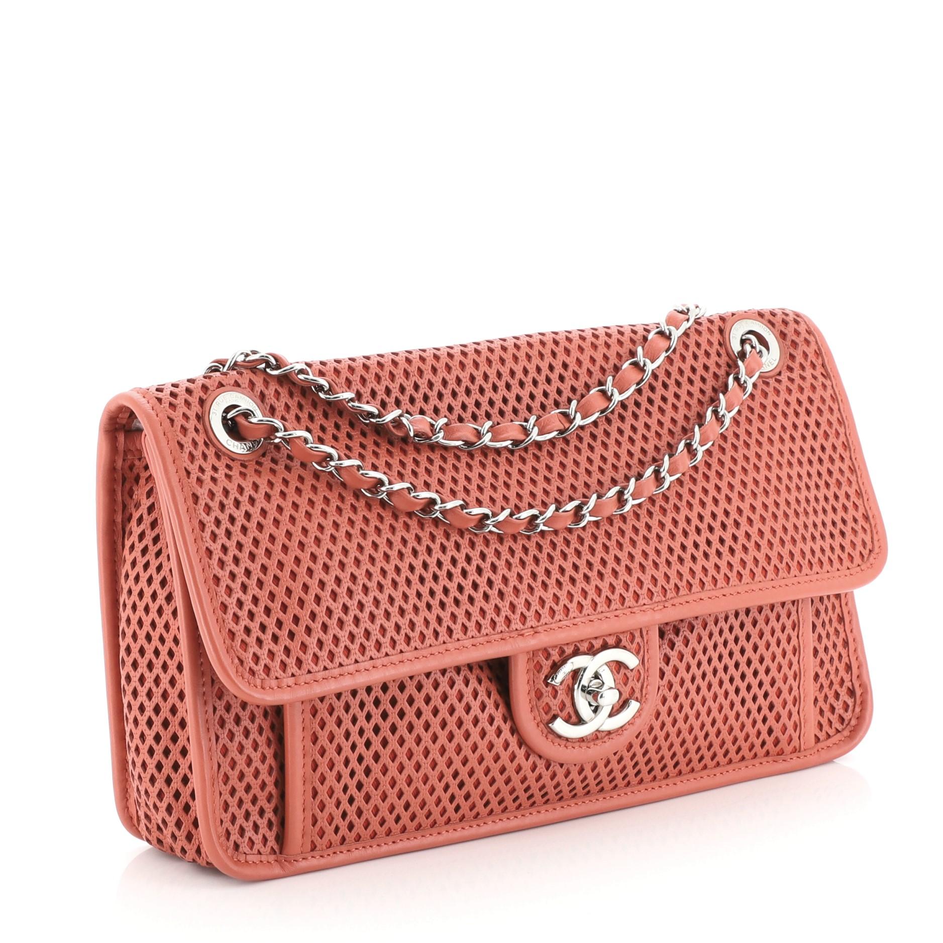 This Chanel Up In The Air Flap Bag Perforated Leather Medium, crafted from red perforated leather, features woven-in leather chain strap, slip pocket under flap, and silver-tone hardware. Its turn-lock closure opens to a red fabric interior with