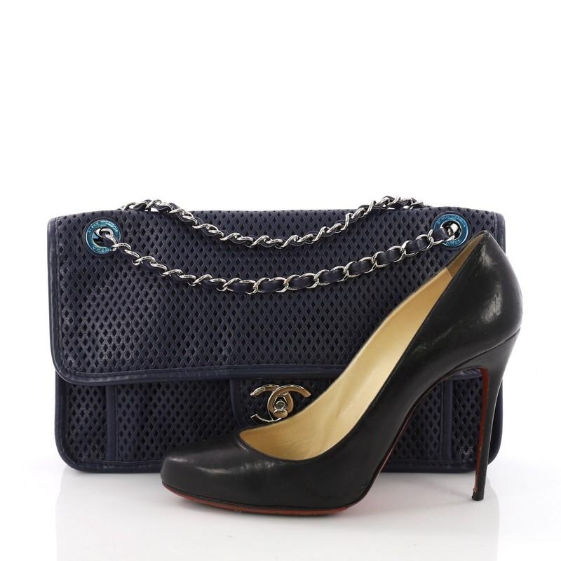 This Chanel Up In The Air Flap Bag Perforated Leather Medium, crafted from blue perforated leather, features a woven-in leather chain strap, an extra front compartment under flap, and silver-tone hardware. Its turn-lock closure opens to a blue