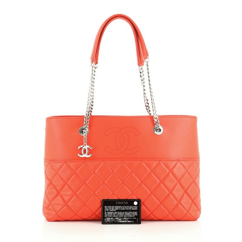 This Chanel Urban Delight Chain Tote Quilted Lambskin Medium, crafted from red quilted lambskin, features dual chain link straps with leather pads, exterior slip pocket, and silver-tone hardware. Its magnetic snap button closure opens to a red