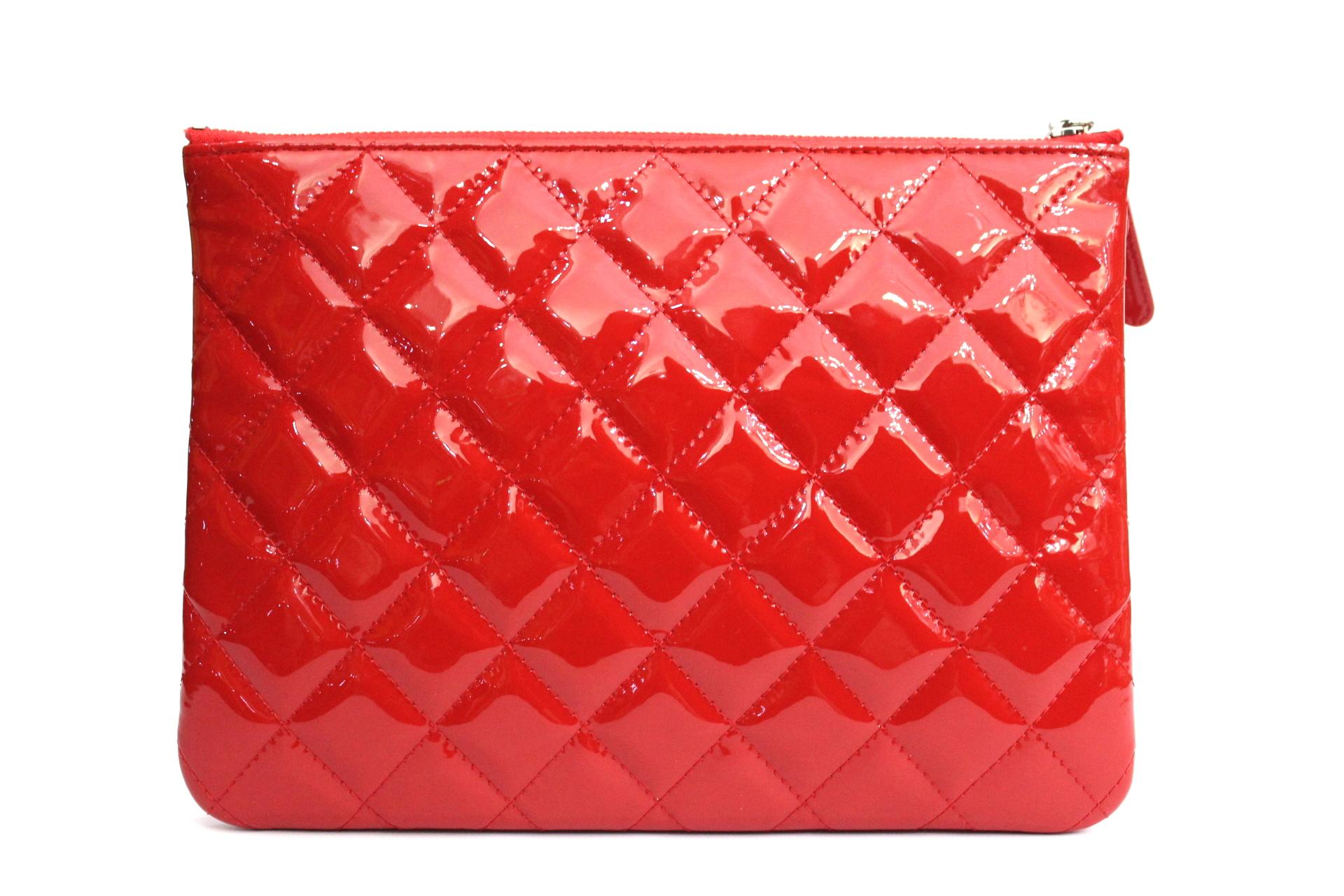 This beautiful Clutch Chanel  is a limited edition bag. Crafted from dark red quilted patent leather, this clutch features heart charm with a ladybug detail on zipper pull, silver CC logo at front and silver-tone hardware accents. Its zip closure