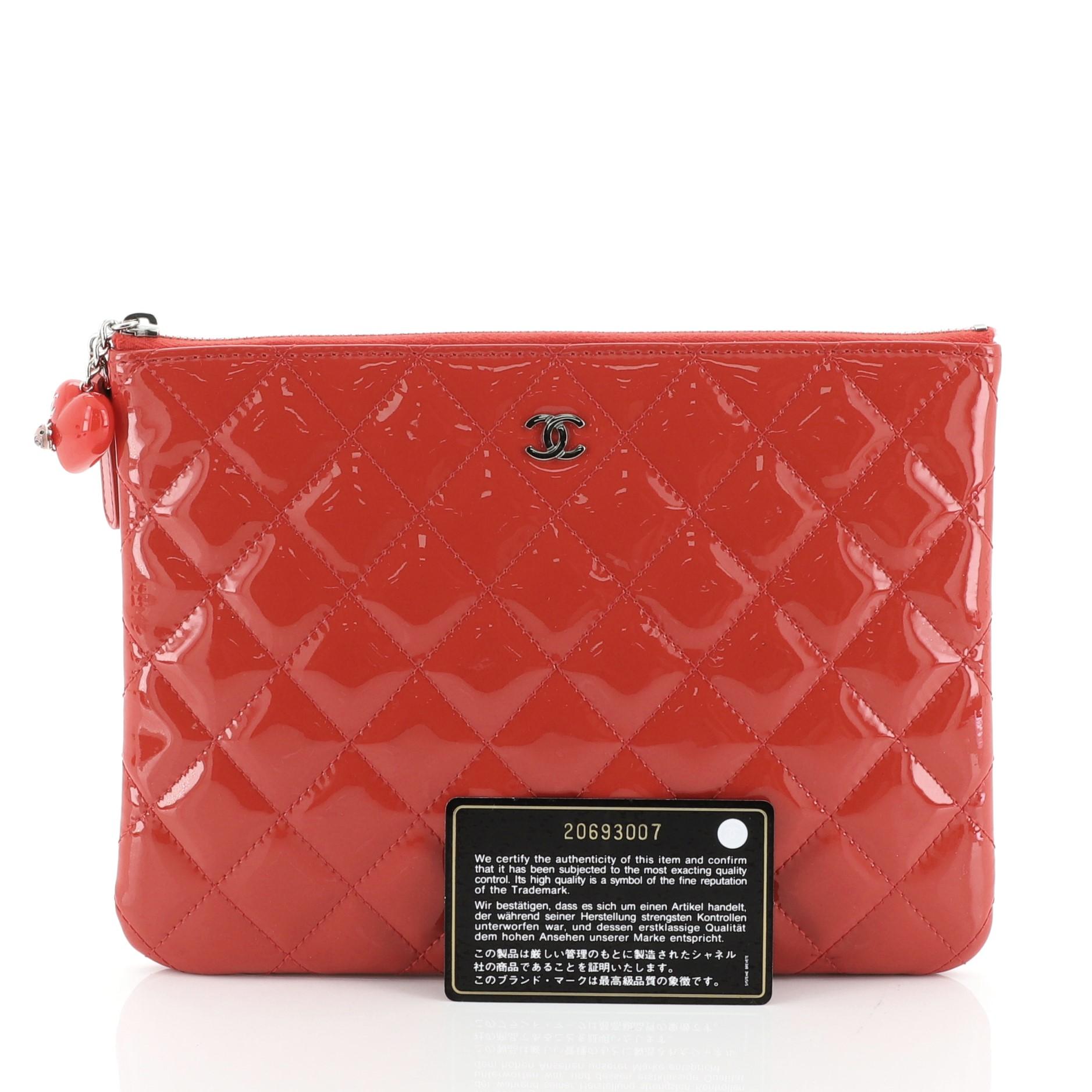 This Chanel Valentine Hearts O Case Clutch Quilted Patent Small, crafted from red quilted patent leather, features heart charm with a ladybug detail on zipper pull, CC logo at front, and silver-tone hardware. Its zip closure opens to a red nylon