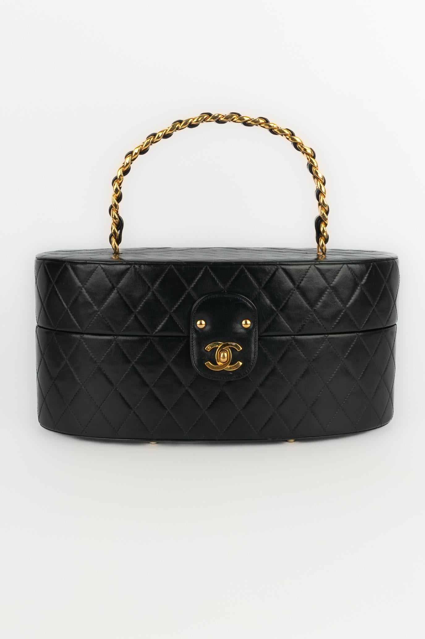 CHANEL - (Made in France) Quilted black lamb leather oval Vanity bag. Golden cc fastener, and rigid interlaced chain handle. Piece with a serial number. A 1986/1988 Collection under the artistic direction of Karl Lagerfeld.

Condition:
Very good