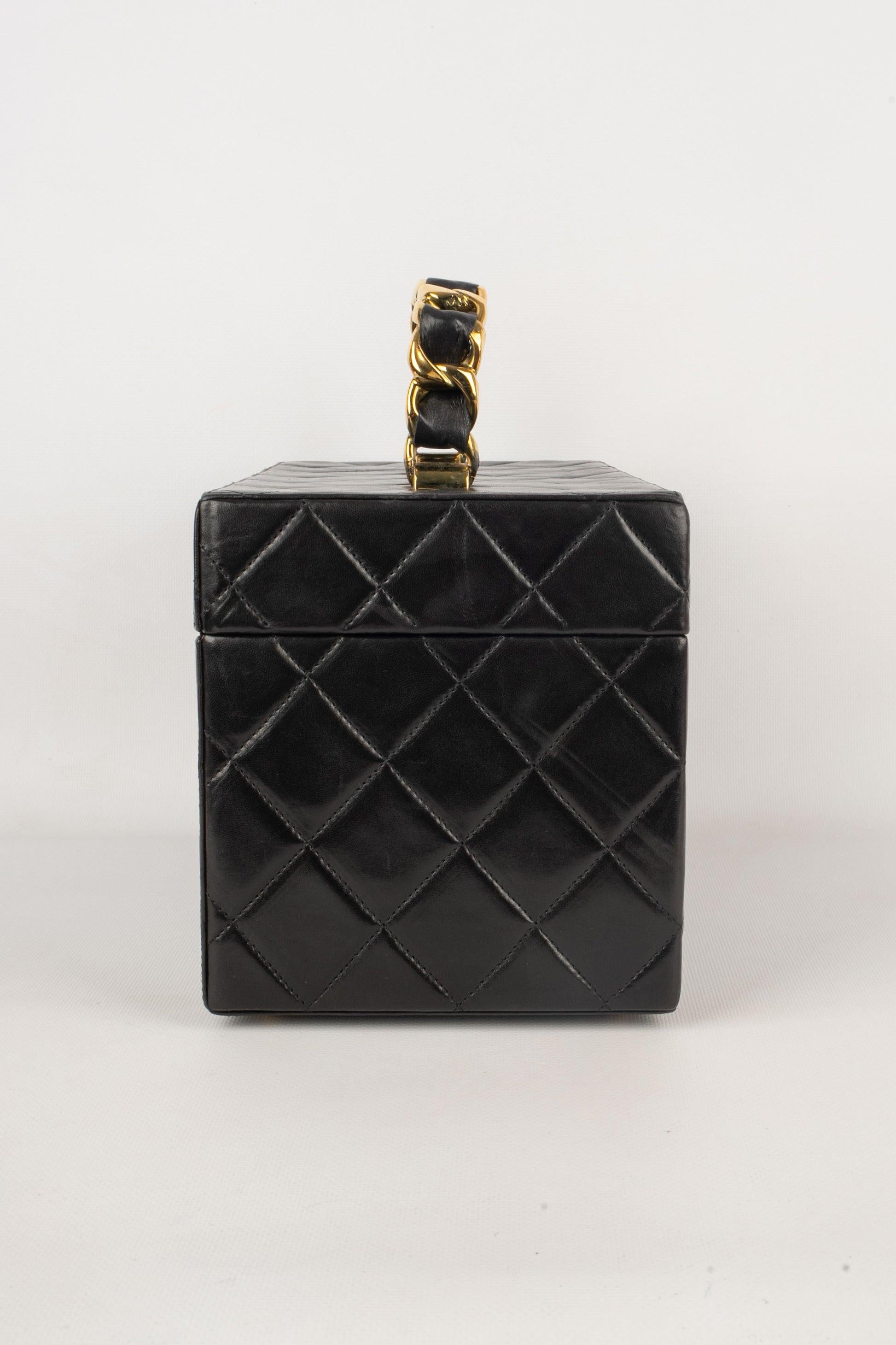 Chanel -(Made in France) Vanity bag in black matte leather, handle with thick chain intertwined with leather. Interior in burgundy leather, pockets and mirror integrated. Card of authenticity and certificate of conformity present. Collection