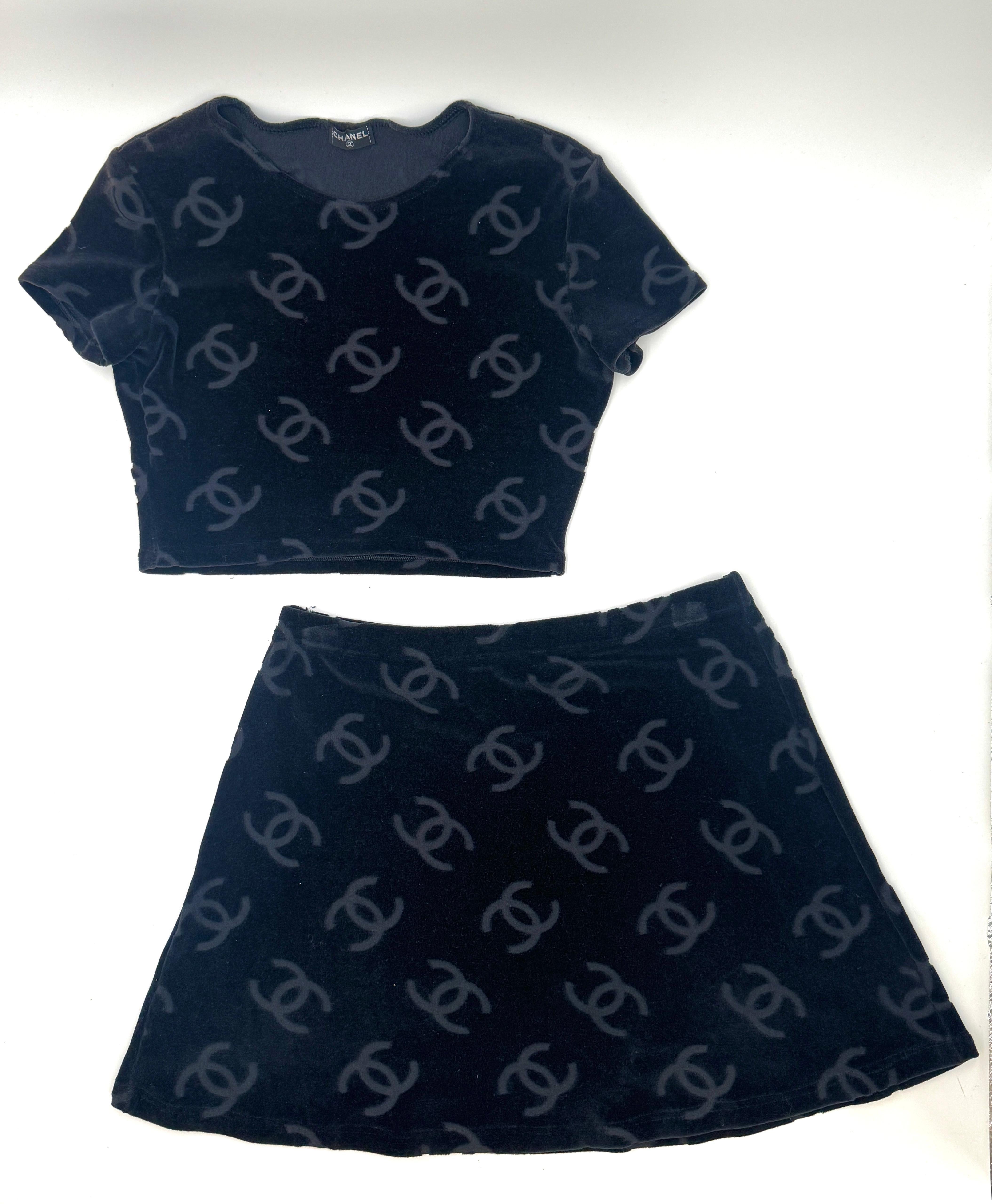 Ein ikonisches zweiteiliges Set aus der Chanel Collection'S von 1996 mit dem charakteristischen CC-Logo auf schwarzem Velours. Dieses Set besteht aus einem kurzärmeligen Oberteil und einem passenden Minirock, beide in ausgezeichnetem Zustand, ohne