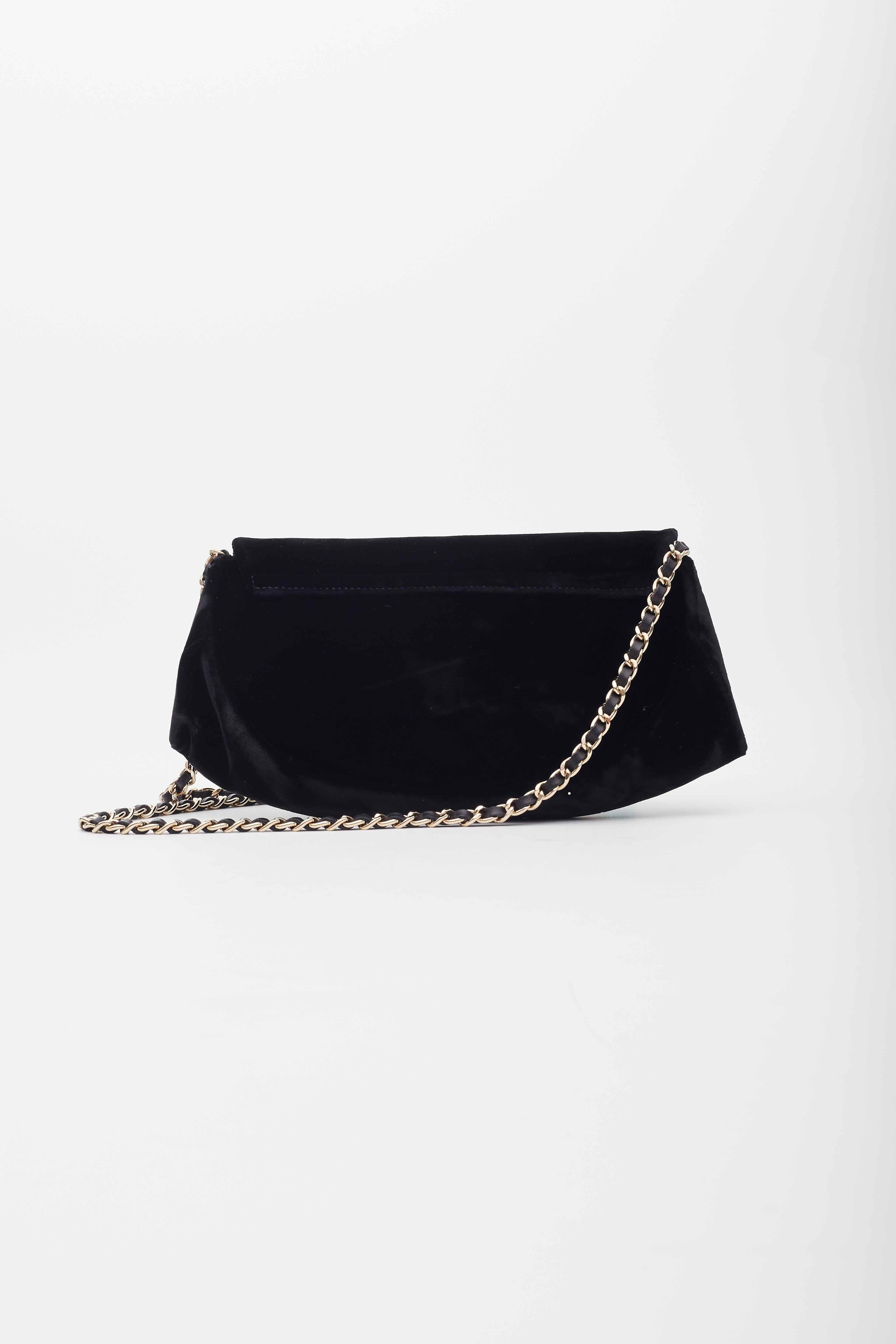 This wallet on a chain is beautifully crafted of luxurious velvet in black. The cross body bag features a below the waist polished gold chain link shoulder strap threaded with black leather and a front flap with a quilted Chanel CC logo. The flap