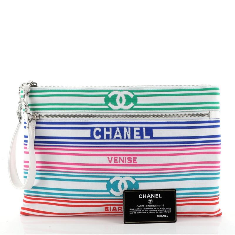 This Chanel Venise Biarritz Zip Pouch Striped Canvas Large, crafted from white, blue and multicolor striped canvas, features chain link and leather handle, exterior zip pockets, and silver-tone hardware. Its top zip closure opens to a blue fabric
