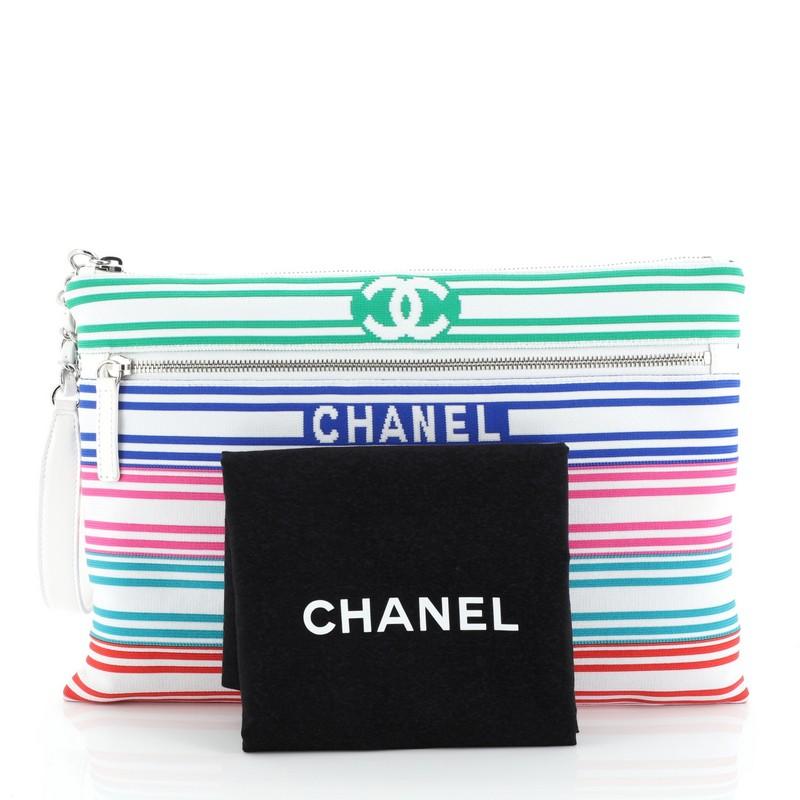 This Chanel Venise Biarritz Zip Pouch Striped Canvas Large, crafted from white, and multicolor striped canvas, features chain link and leather handle, exterior zip pockets, and silver-tone hardware. Its top zip closure opens to a blue fabric