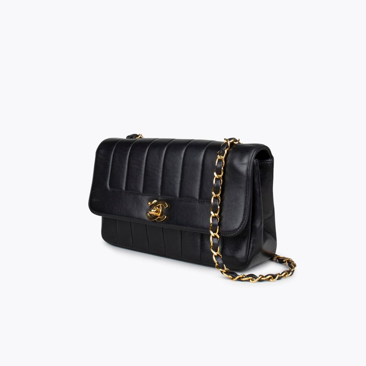 Black vertical quilted lambskin vintage Chanel flap crossbody bag with

– Gold-tone hardware
– Single chain-link shoulder strap
– Burgundy leather lining
– Dual pockets at interior wall; one with zip closure and CC turn-lock closure at front