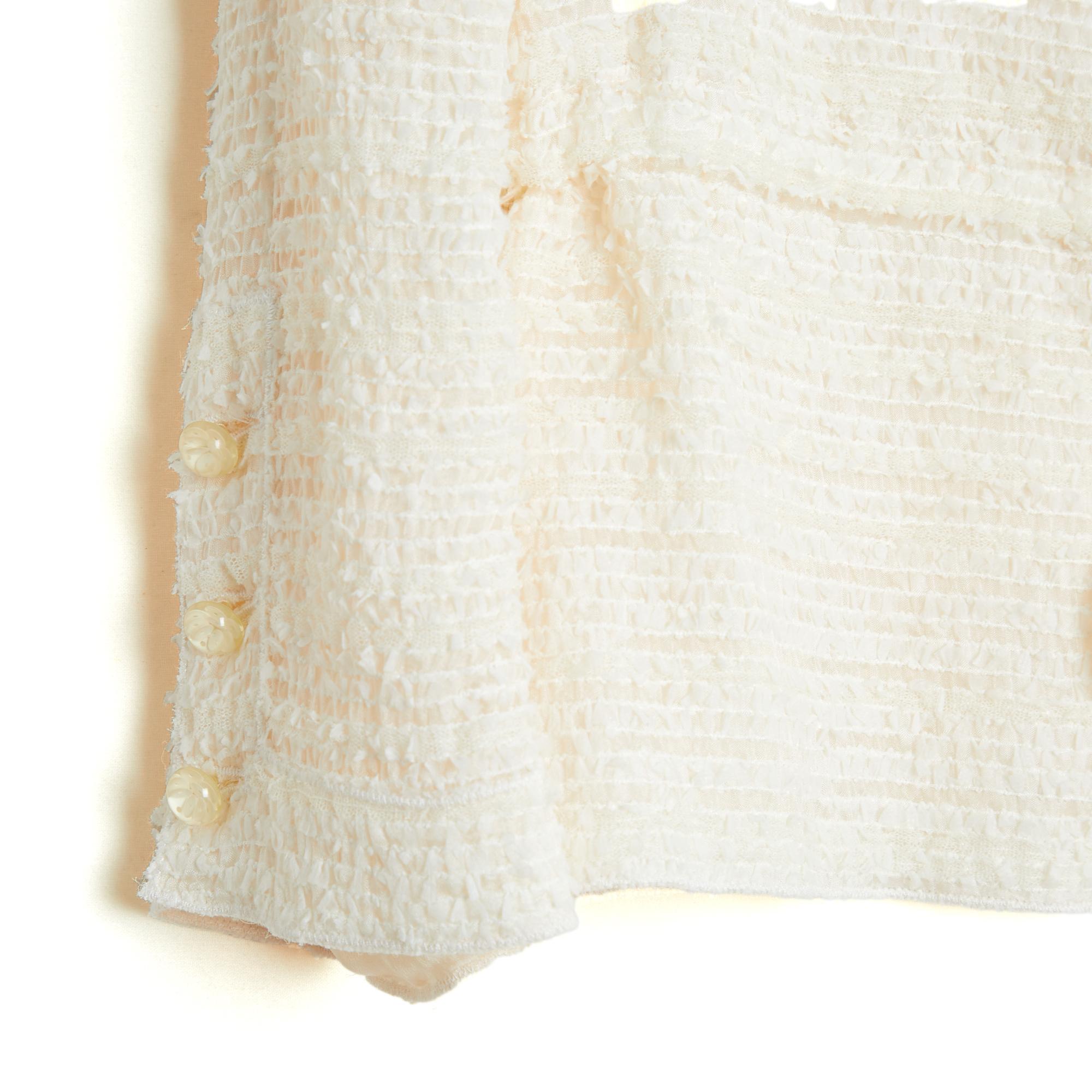 Chanel jacket in light polyamide and cotton tweed, small collar closed in front by 4 camellia buttons in translucent resin, waist tightened (or not) by a tie, 3/4 sleeves closed by 3 coordinated buttons, ecru silk lining. No size label but the