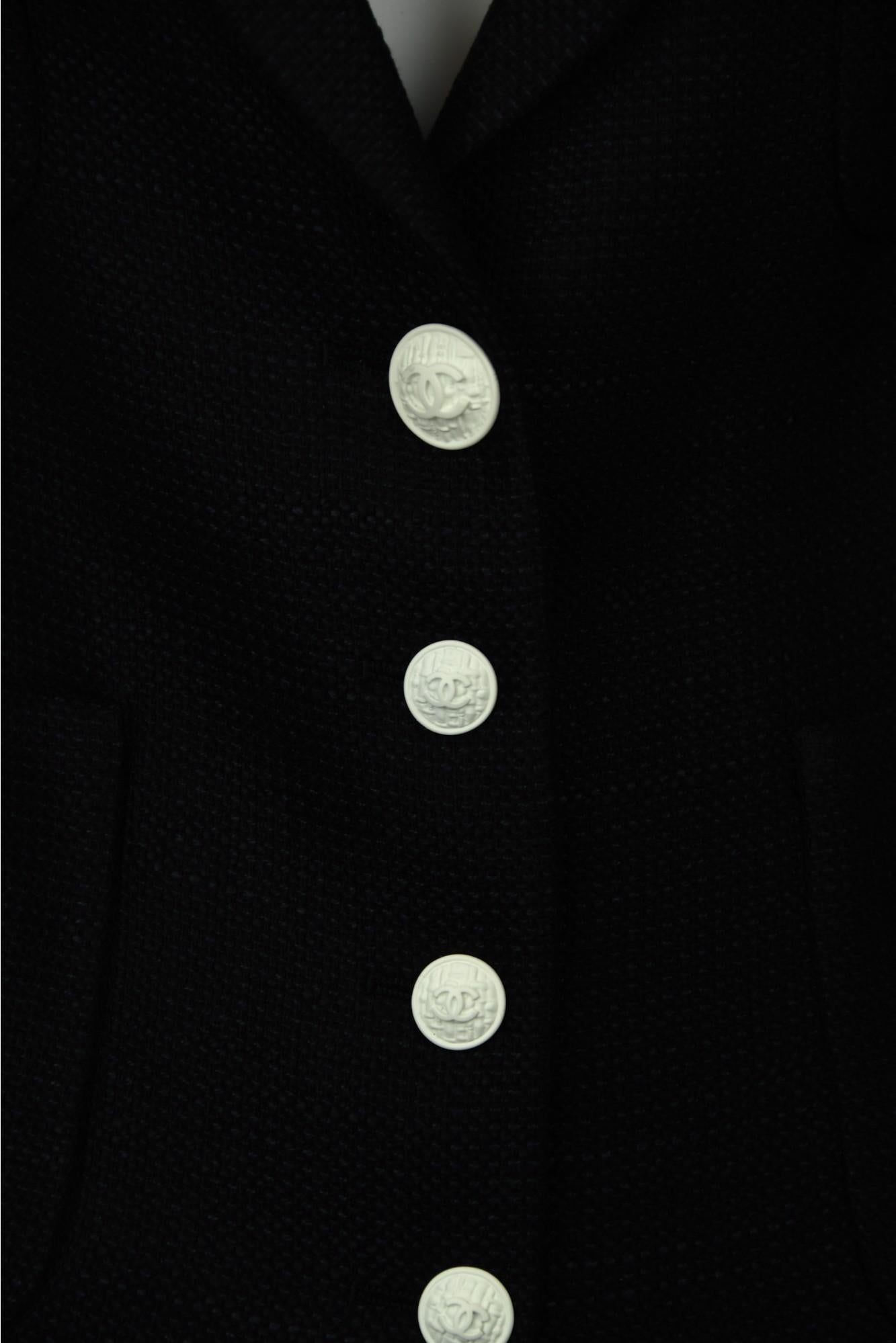 From Chanel’s 2007 Spring Collection (07P), this vintage black blazer reimagines classic tailoring with minimalist elegance. Made in France from a subtly textured woven fabric, the piece features a deep V neckline and sharply structured shoulders