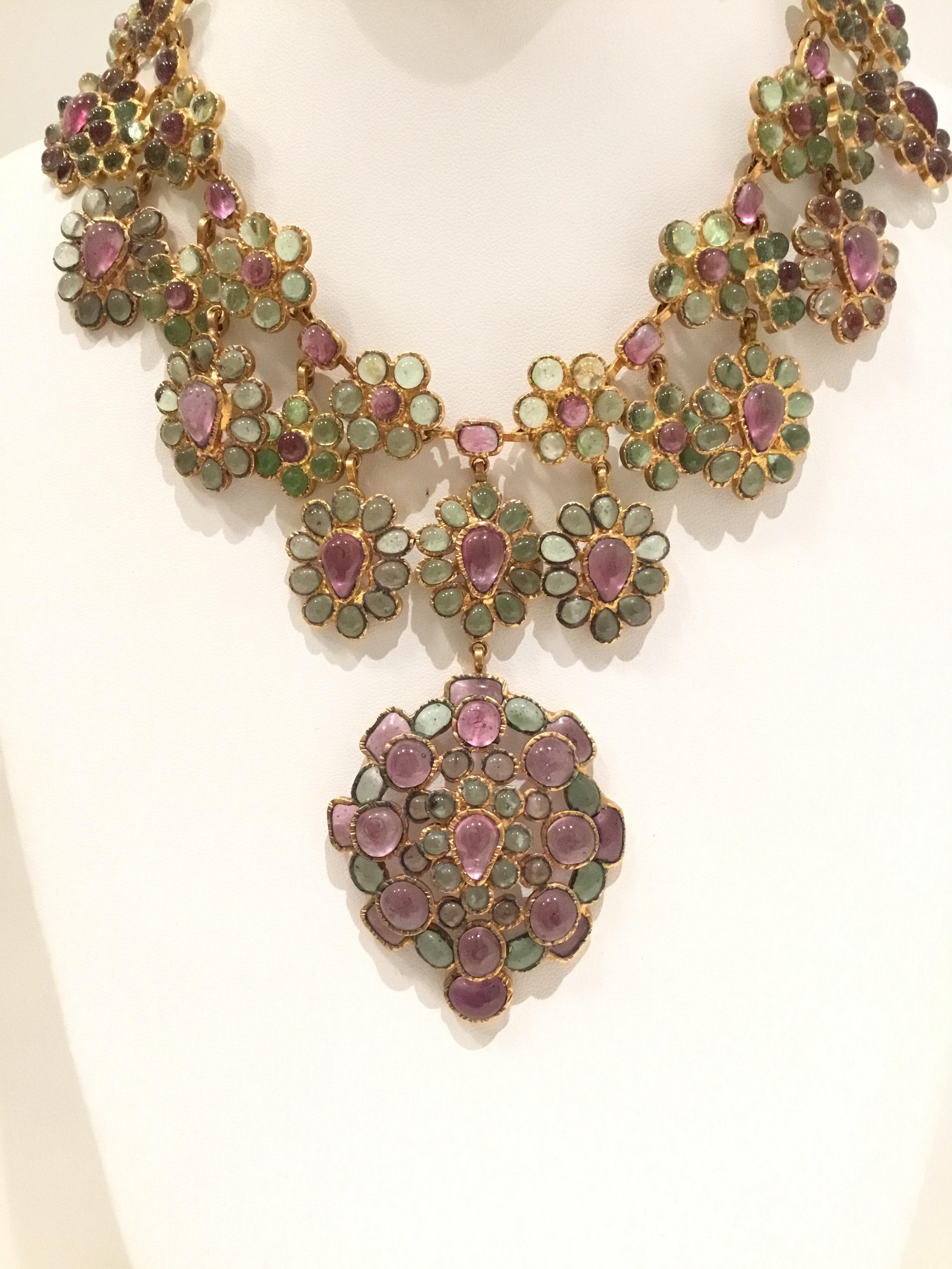 Beautiful, vintage Chanel necklace from the 1970’s feature a pink, purple, and peridot-colored glass gripoix stones on a gold-tone Metal with a hook fastening. 
Made in France