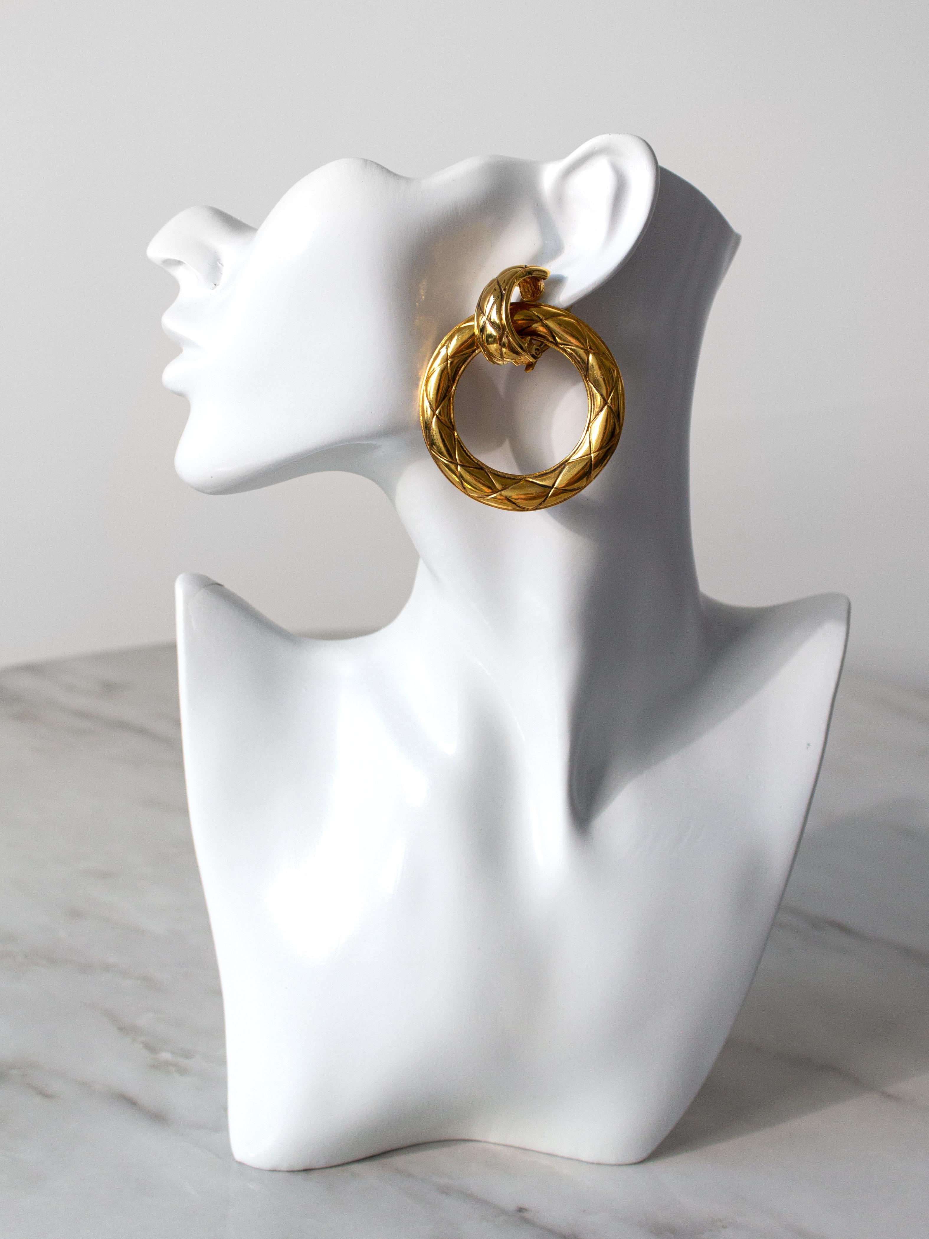 Presenting a stunning pair of vintage Chanel clip-on earrings, the epitome of 80s chic. Crafted from quilted gold-plated metal, these convertible earrings redefine versatility. They effortlessly transition from chic hoops to a quilted clip-on style,