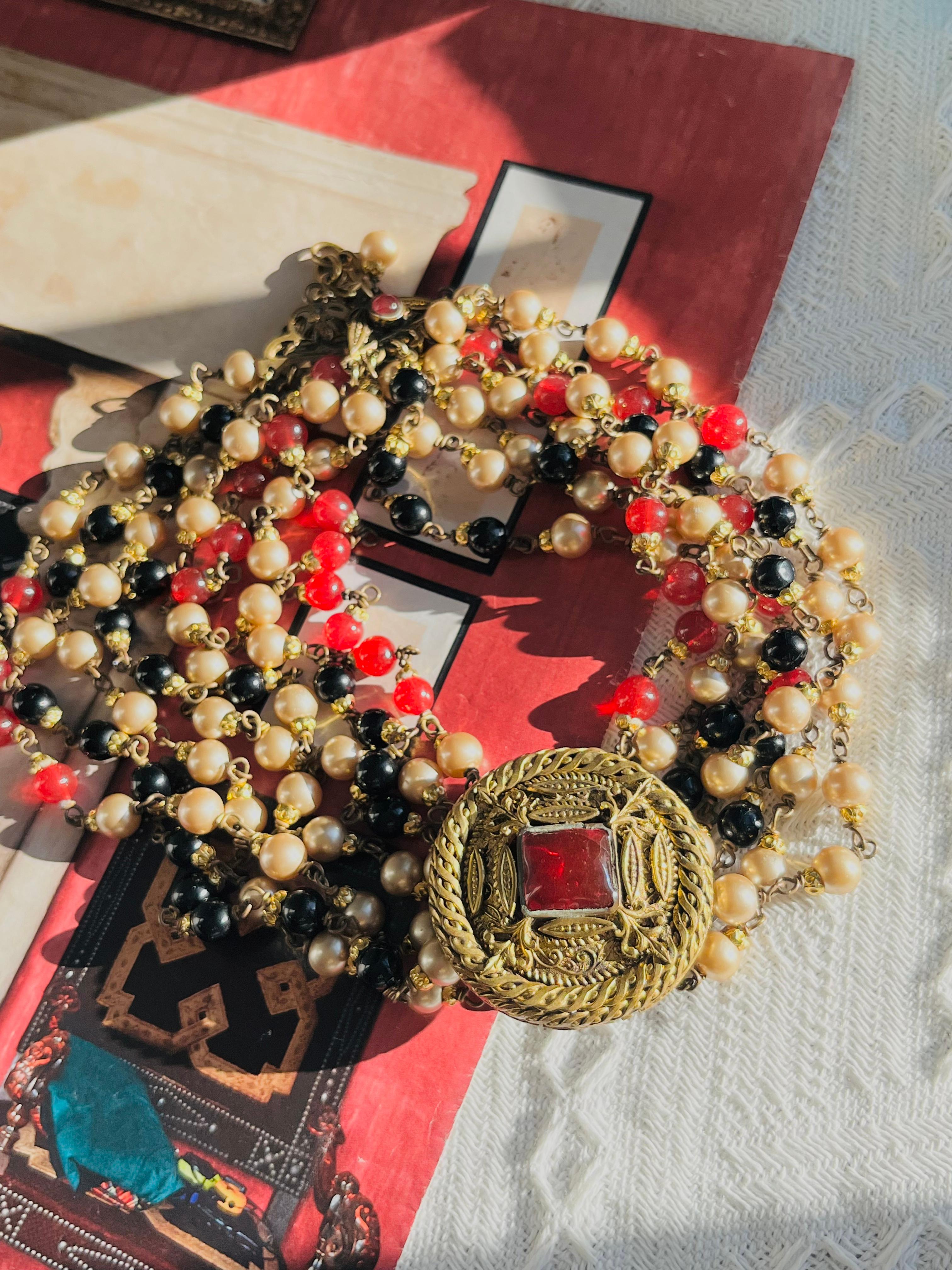 Chanel Vintage 1984 Luxury Gripoix Baroque Square Ruby Red Relief Engraved Pendant Pearls Onyx White Black Cabochon Beads 7 Layers Strands Tassel Choker Collar Necklace, Silver Plated 

Très bon état. Très légères rayures ou pertes de couleur, à