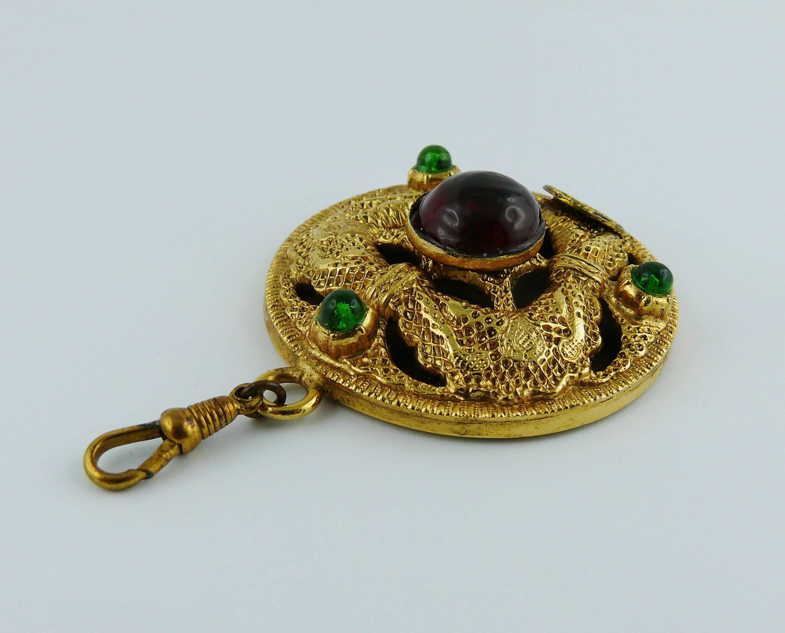 Chanel vintage rare 1984 round mirrored pendant.

Gold tone textured metal embellished with red and green gripoix glass cabochons on one side and mirror at the rear. 

Equipped with pinch clasp that attaches to a chain. 

Marked CHANEL 1984.

Comes