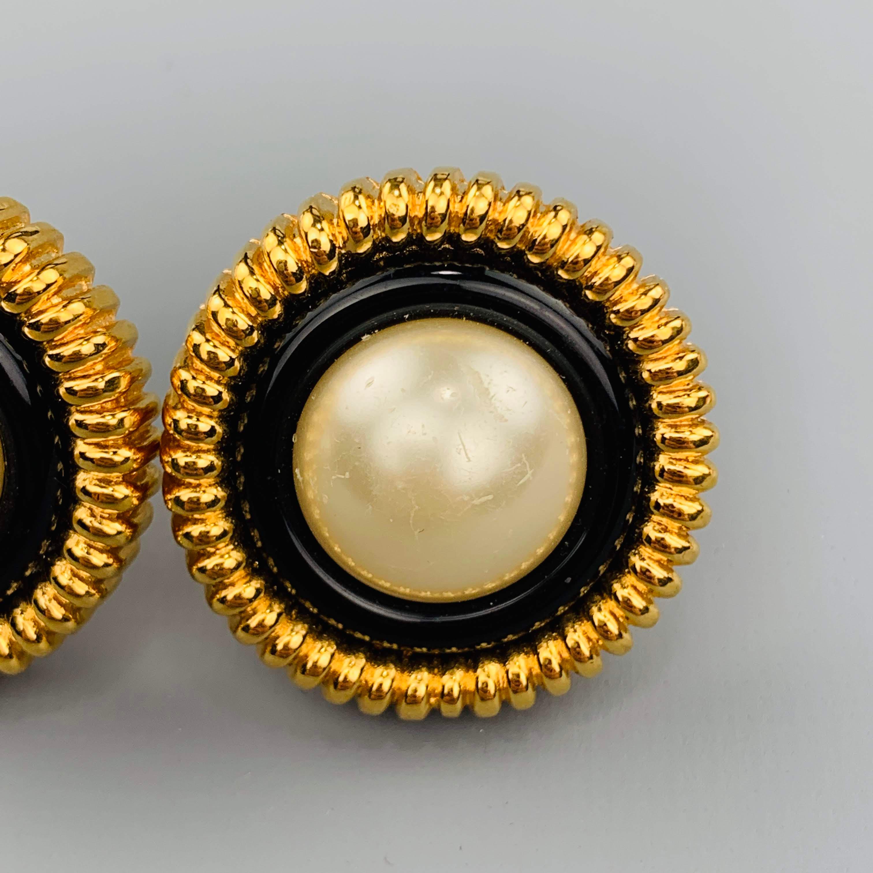 Vintage CHANEL Season 23 circa 1986 clip on earrings feature a yellow gold tone textured circle with a faux pearl center encased with a black border. Made in France.
 
Very Good Pre-Owned Condition.
Marked: 23
 
3.5 x 3.5 cm.