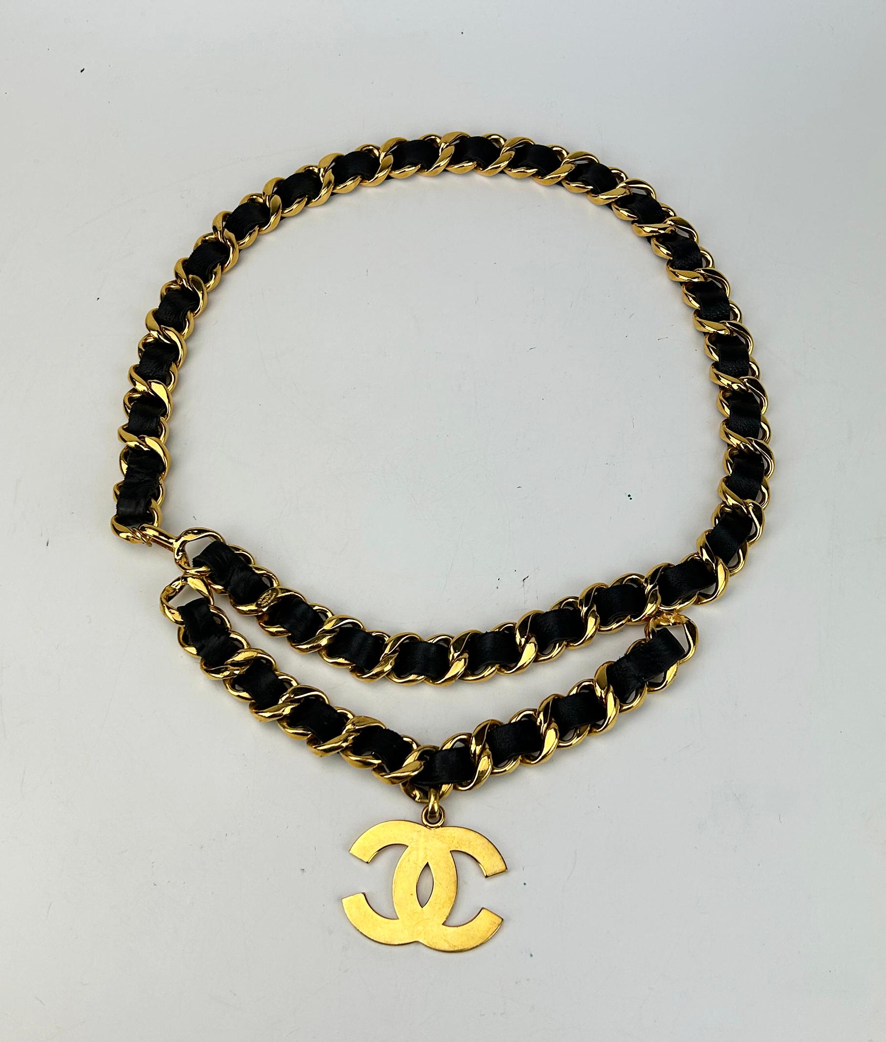 Chanel Vintage 1990s Runway Iconic Double Chain Belt Necklace in very good condition. Thick and chunky gold chain with black leather woven throughout. hook closure. double chain detail. Iconic CC logo charm on double chain. Can be worn as a belt or