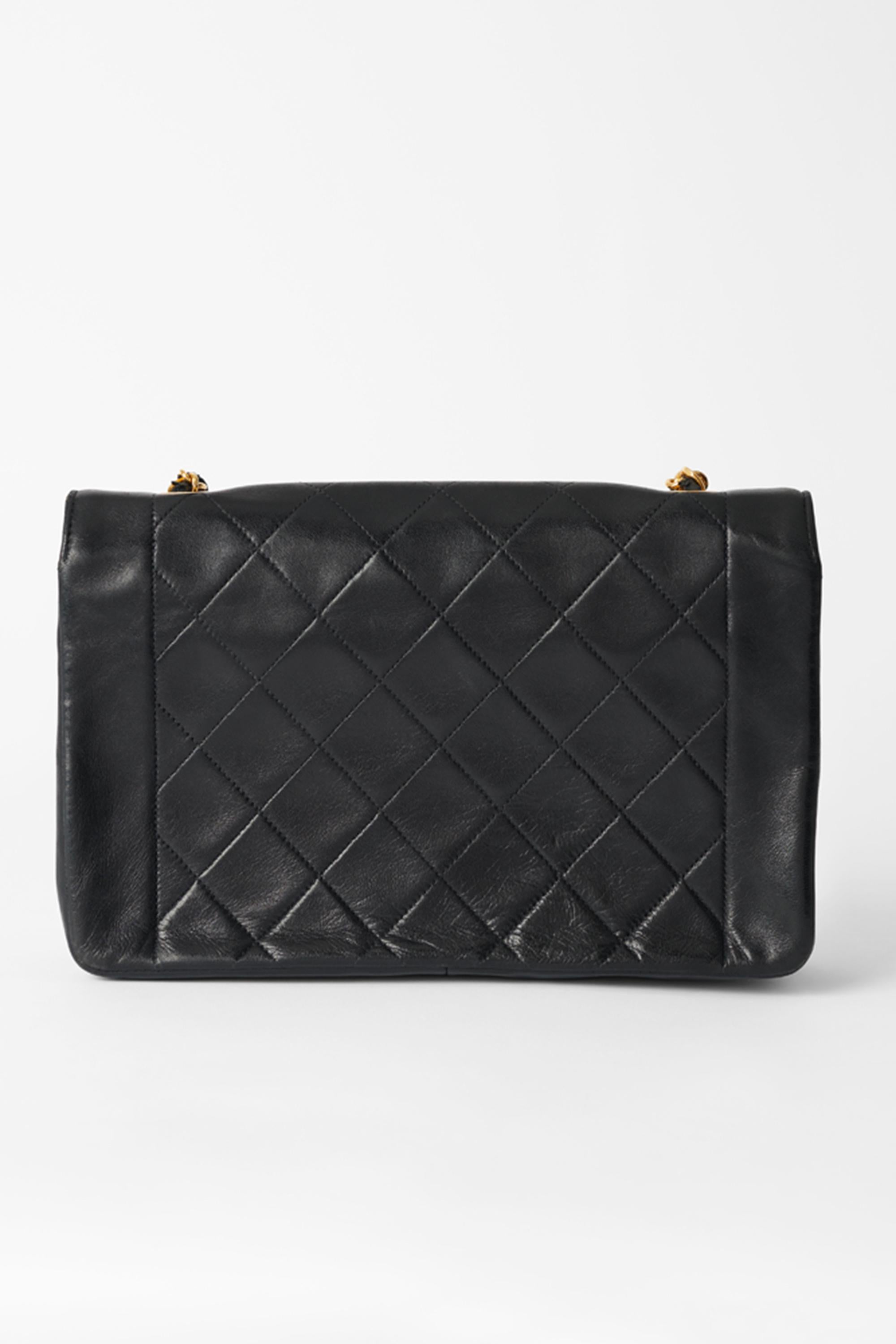 We are excited to present this iconic Vintage 1991/92  Chanel Diana flap bag in black quilted lambskin leather, gold metal hardware, a chain-handle in 24k gold metal interlaced with black leather for a shoulder carry gold plated metal closure on